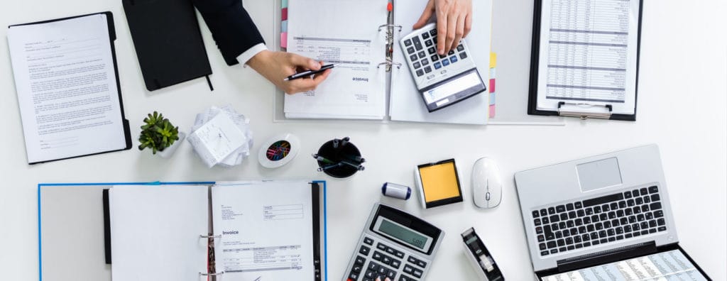 Accounting Administrator using a calculator to determine financial numbers.
